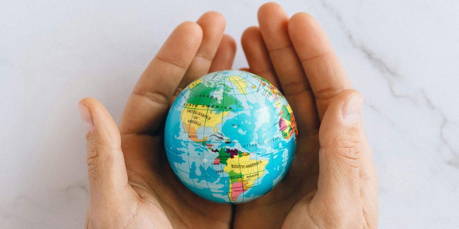 Hands holding a globe - where will you Go Travelling?